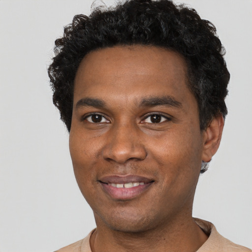 Joyful black young-adult male with short  black hair and brown eyes