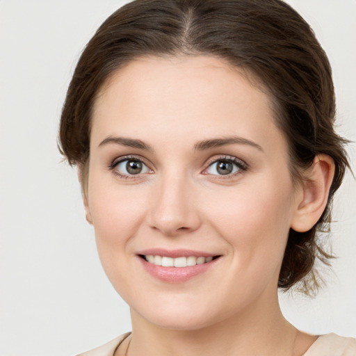 Joyful white young-adult female with medium  brown hair and green eyes