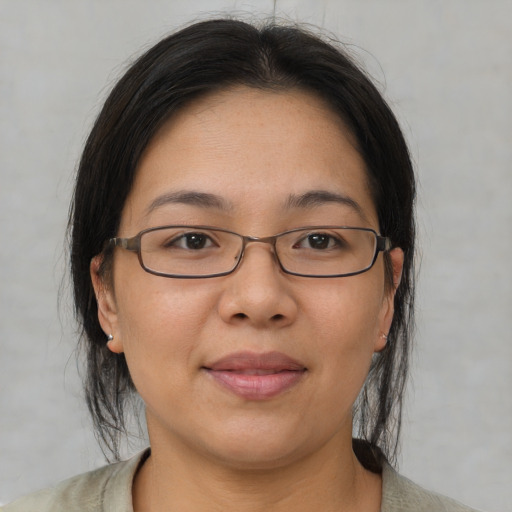 Joyful asian adult female with medium  brown hair and brown eyes