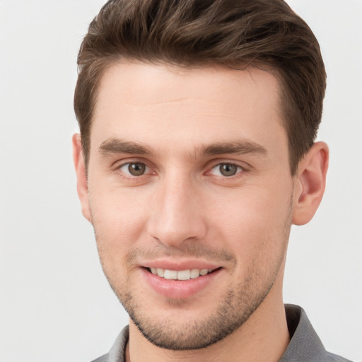 Joyful white young-adult male with short  brown hair and grey eyes