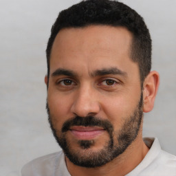 Joyful latino young-adult male with short  black hair and brown eyes