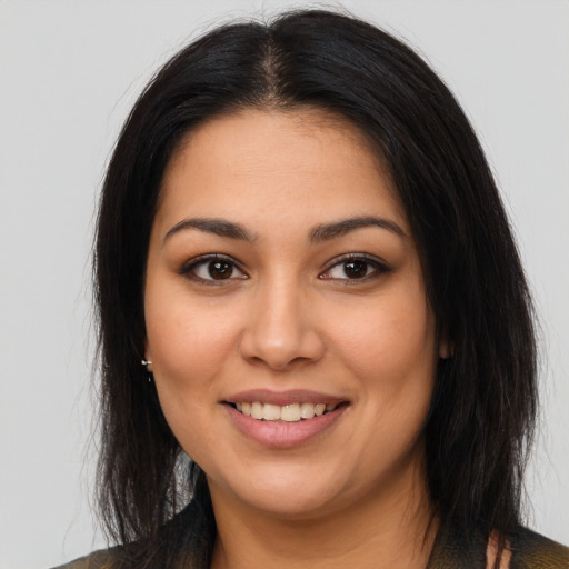 Joyful latino young-adult female with long  brown hair and brown eyes