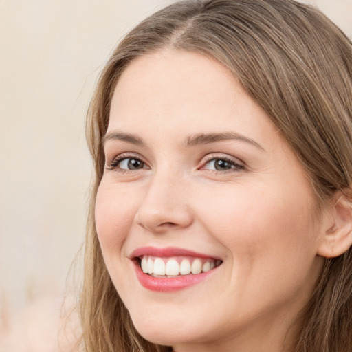 Joyful white young-adult female with long  brown hair and grey eyes