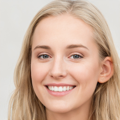 Joyful white young-adult female with long  brown hair and blue eyes