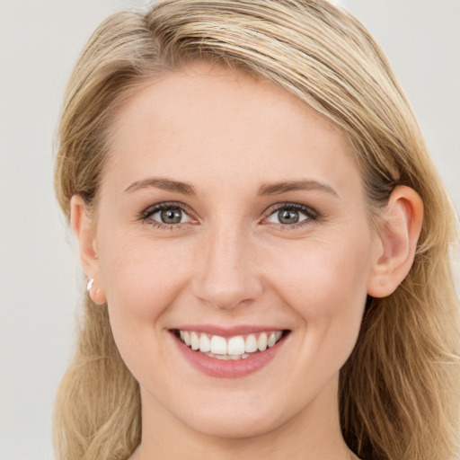 Joyful white young-adult female with long  brown hair and blue eyes