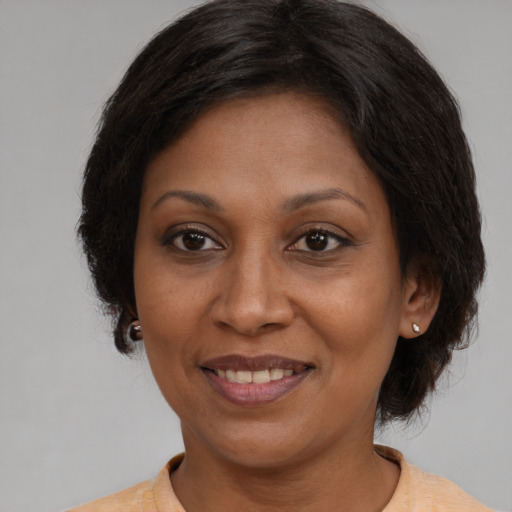 Joyful latino adult female with medium  brown hair and brown eyes