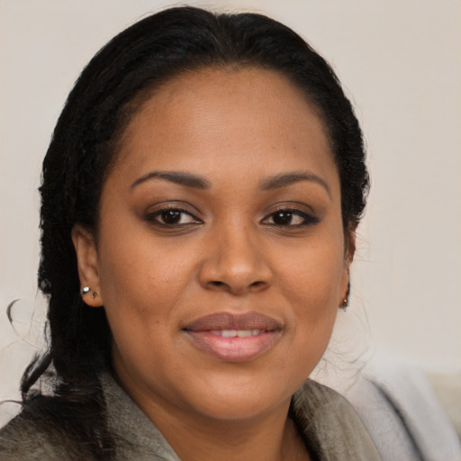 Joyful black young-adult female with long  brown hair and brown eyes
