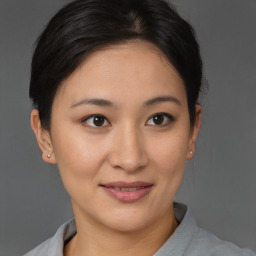 Joyful asian young-adult female with medium  brown hair and brown eyes