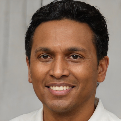 Joyful latino adult male with short  brown hair and brown eyes