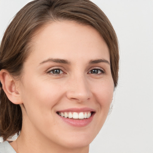 Joyful white young-adult female with medium  brown hair and green eyes