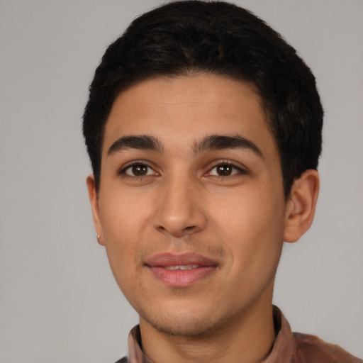 Joyful latino young-adult male with short  black hair and brown eyes