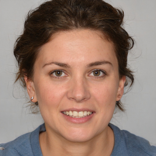 Joyful white adult female with medium  brown hair and blue eyes