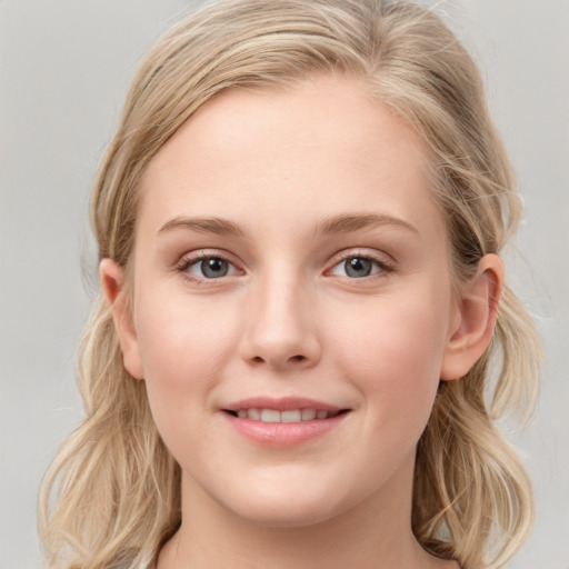 Joyful white young-adult female with long  brown hair and blue eyes