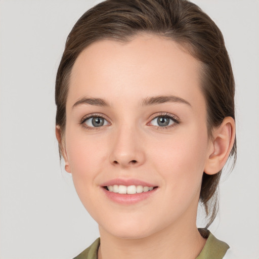 Joyful white young-adult female with medium  brown hair and grey eyes