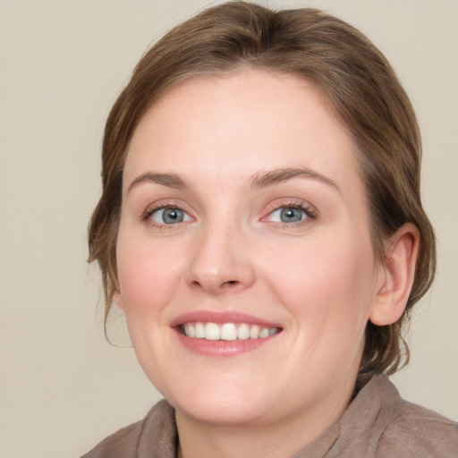 Joyful white young-adult female with medium  brown hair and grey eyes