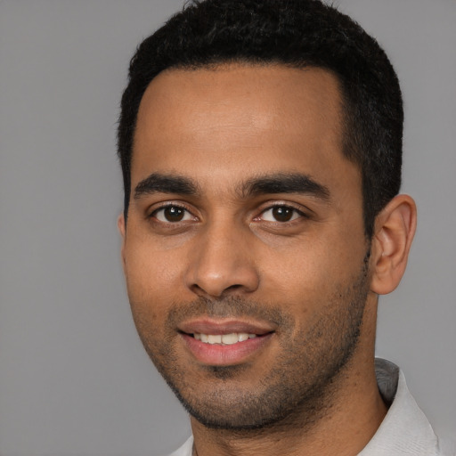 Joyful latino young-adult male with short  black hair and brown eyes
