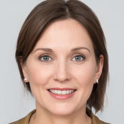 Joyful white young-adult female with medium  brown hair and grey eyes