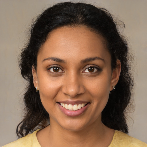 Joyful black young-adult female with medium  brown hair and brown eyes