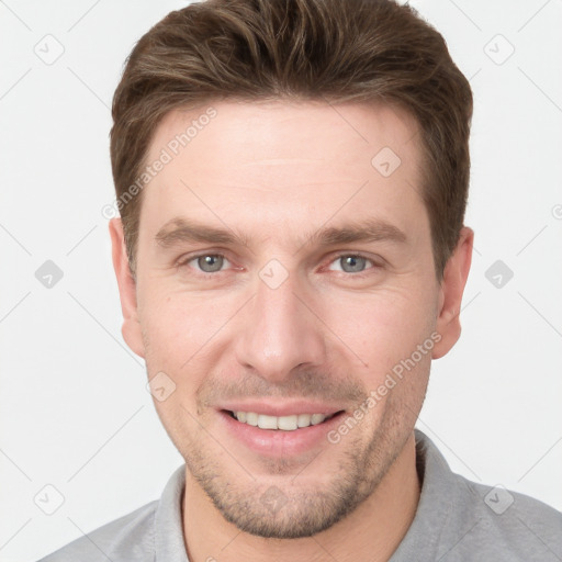 Joyful white young-adult male with short  brown hair and grey eyes