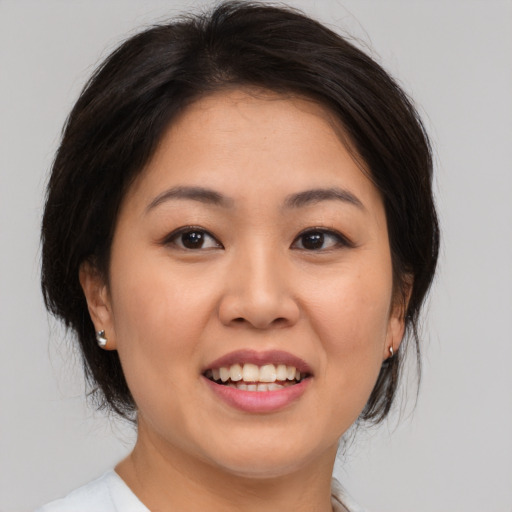 Joyful asian young-adult female with medium  brown hair and brown eyes