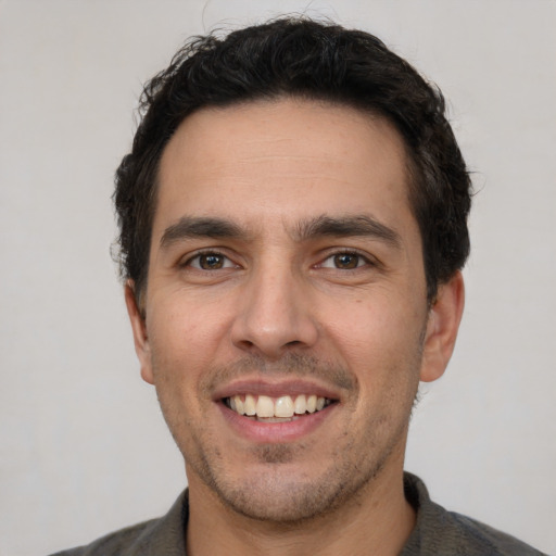 Joyful white young-adult male with short  black hair and brown eyes