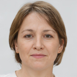 Joyful white adult female with medium  brown hair and grey eyes