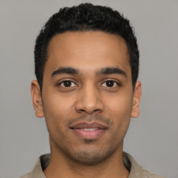 Joyful latino young-adult male with short  black hair and brown eyes