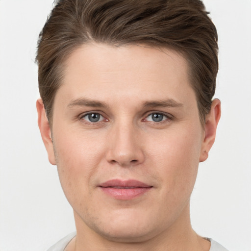 Joyful white young-adult male with short  brown hair and grey eyes