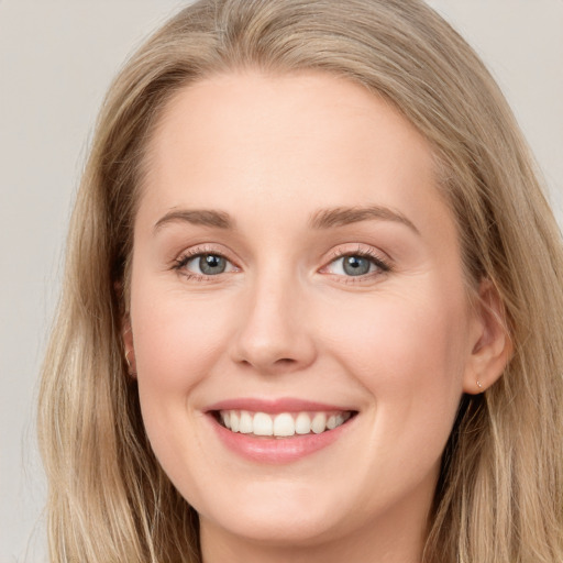 Joyful white young-adult female with long  brown hair and blue eyes