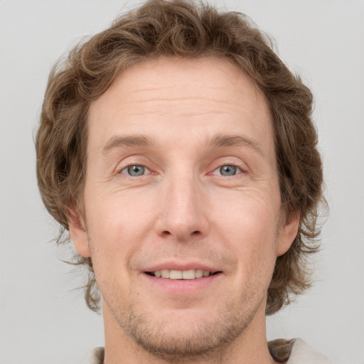 Joyful white adult male with short  brown hair and grey eyes