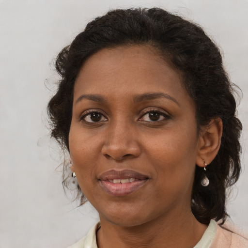 Joyful black adult female with medium  brown hair and brown eyes