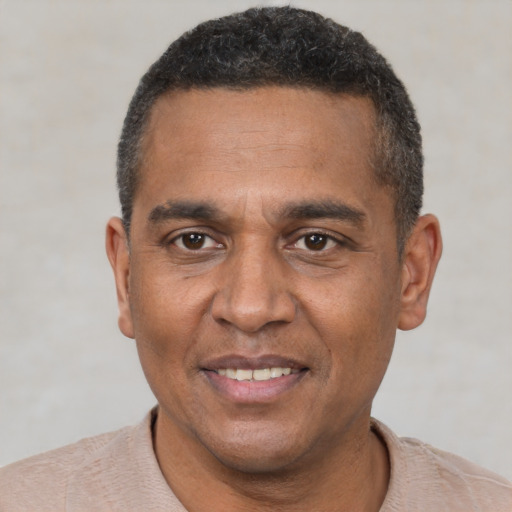 Joyful black adult male with short  black hair and brown eyes