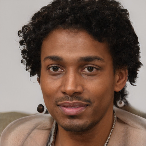 Joyful black young-adult male with short  black hair and brown eyes
