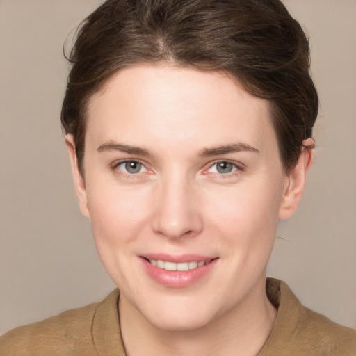 Joyful white young-adult female with short  brown hair and grey eyes