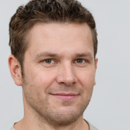 Joyful white adult male with short  brown hair and grey eyes