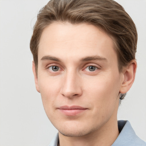 Joyful white young-adult male with short  brown hair and grey eyes