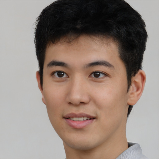 Joyful asian young-adult male with short  brown hair and brown eyes