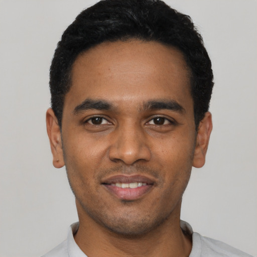 Joyful black young-adult male with short  black hair and brown eyes