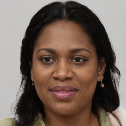 Joyful black adult female with long  brown hair and brown eyes