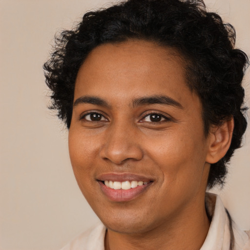Joyful black young-adult female with long  brown hair and brown eyes