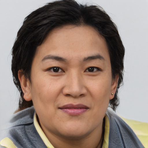 Joyful asian adult female with medium  brown hair and brown eyes