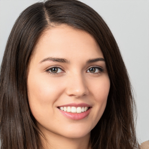 Joyful white young-adult female with long  brown hair and brown eyes