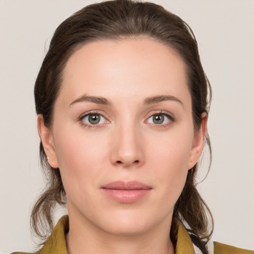 Joyful white young-adult female with medium  brown hair and grey eyes