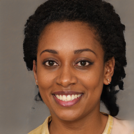 Joyful black young-adult female with long  black hair and brown eyes