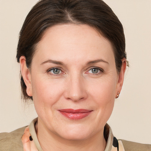 Joyful white adult female with medium  brown hair and grey eyes