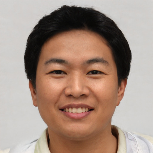 Joyful asian young-adult male with short  black hair and brown eyes