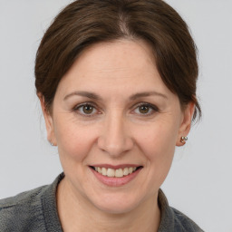 Joyful white adult female with medium  brown hair and grey eyes