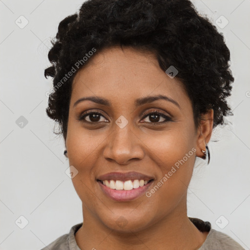 Joyful black young-adult female with short  black hair and brown eyes