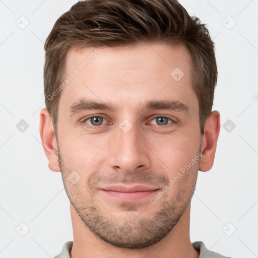 Joyful white young-adult male with short  brown hair and grey eyes