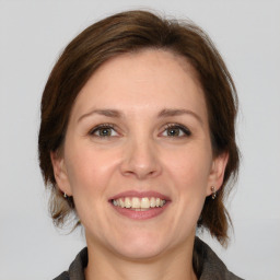 Joyful white adult female with medium  brown hair and grey eyes